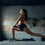 femeie tanara facand exercitii de stretching in interior