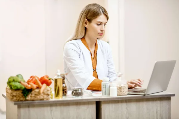 medic nutritionist in cabinetul medical, avand alimente pe masa
