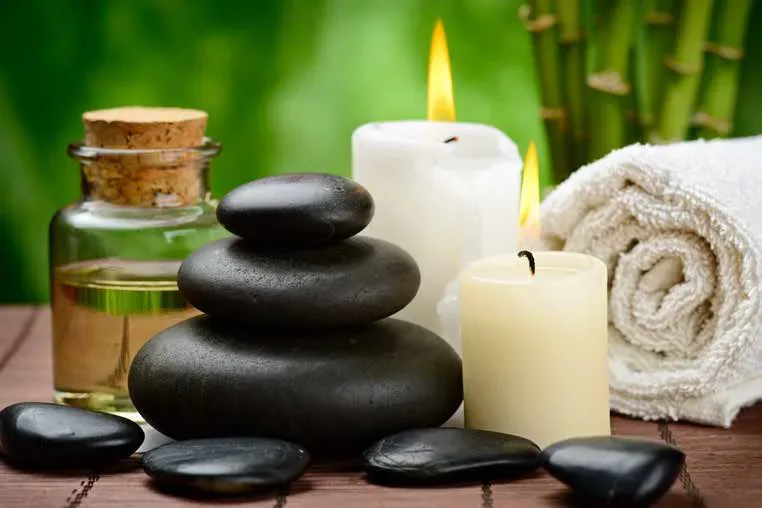 ulei de masaj, lumanari, prosop si pietre speciale pentru masajul terapeutic cu pietre calde